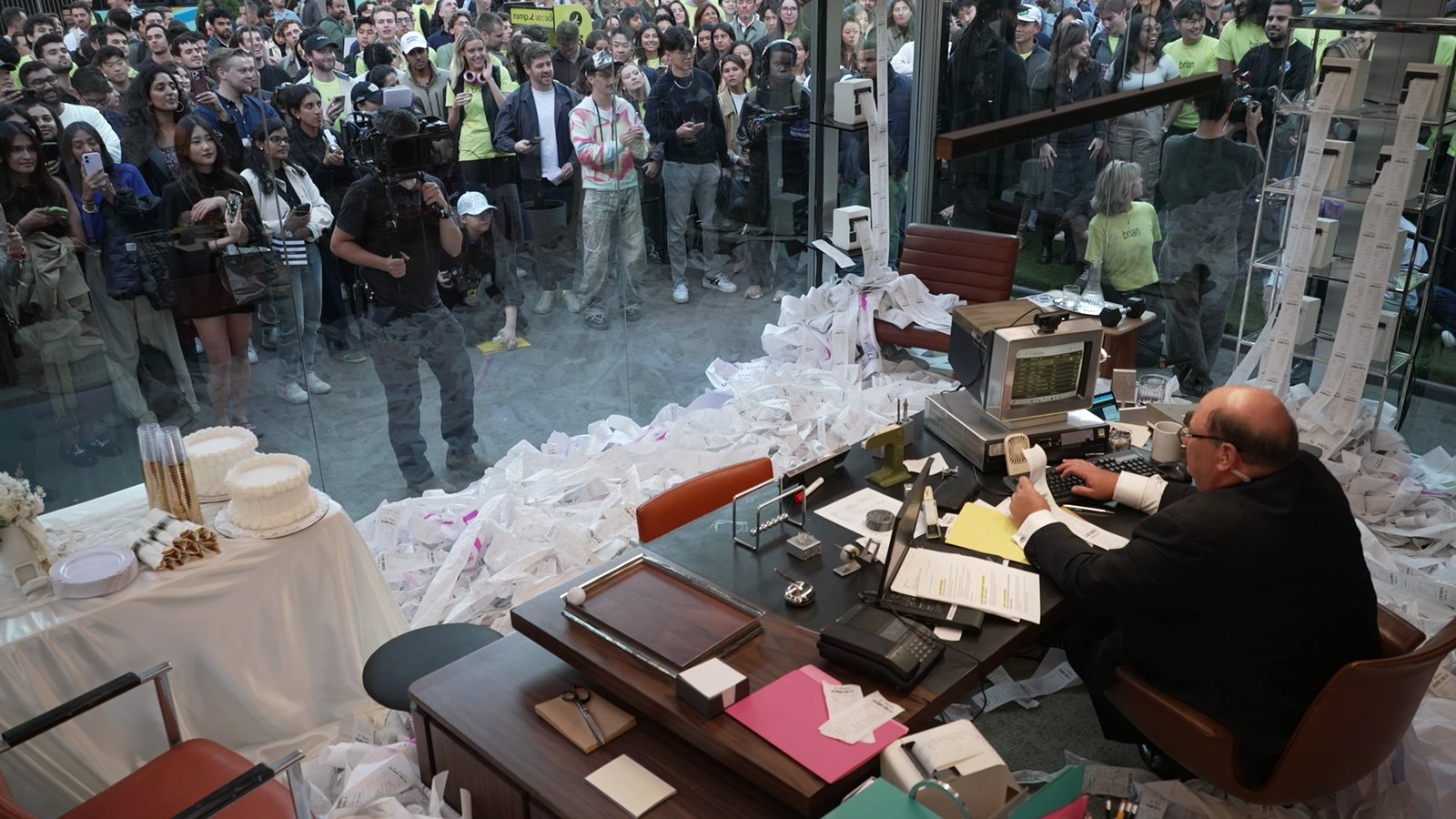 Crowd gathered outside the glass box watching Brian process receipts