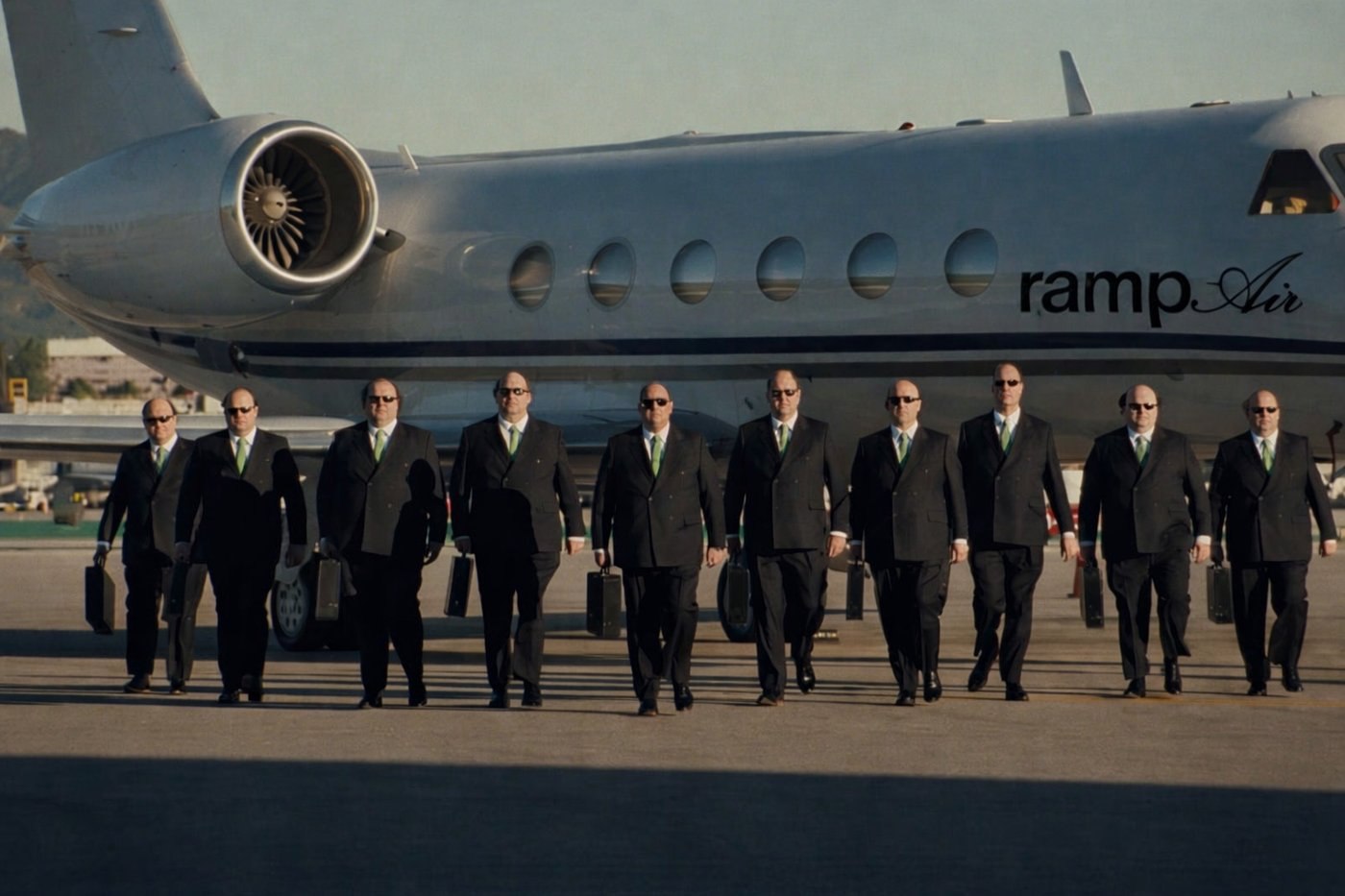 Ten Brians walking off a private jet labeled 'ramp Air'