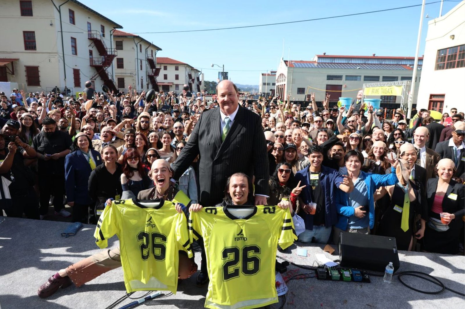 The two look-alike contest winners on stage with Brian Baumgartner holding Ramp #26 jerseys, crowd cheering behind them
